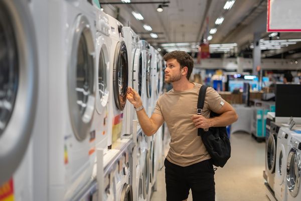 A man reviewing a front load washer in a store